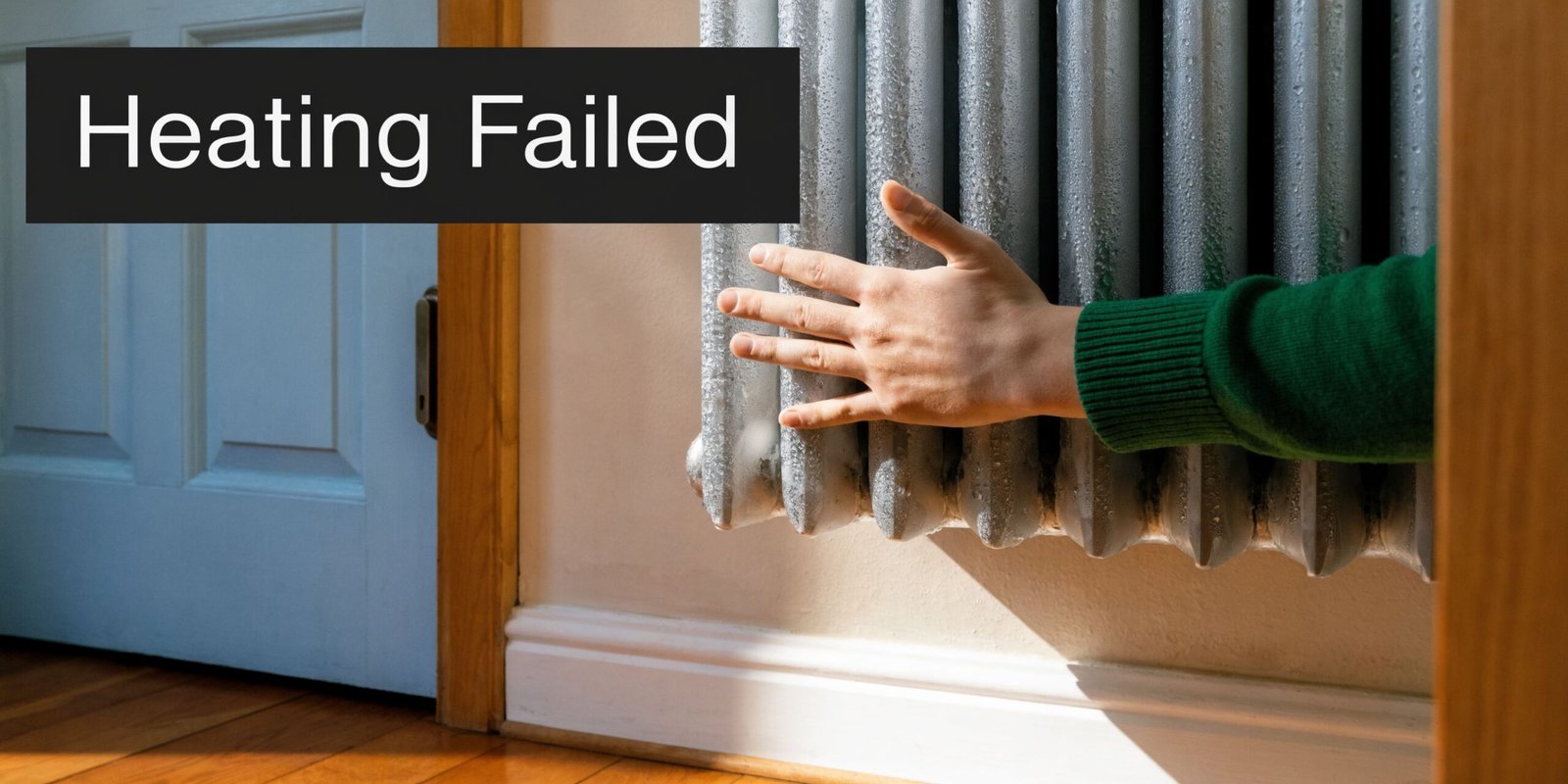 A person touching a frozen metal radiator in a home, representing heating failure or a broken boiler.